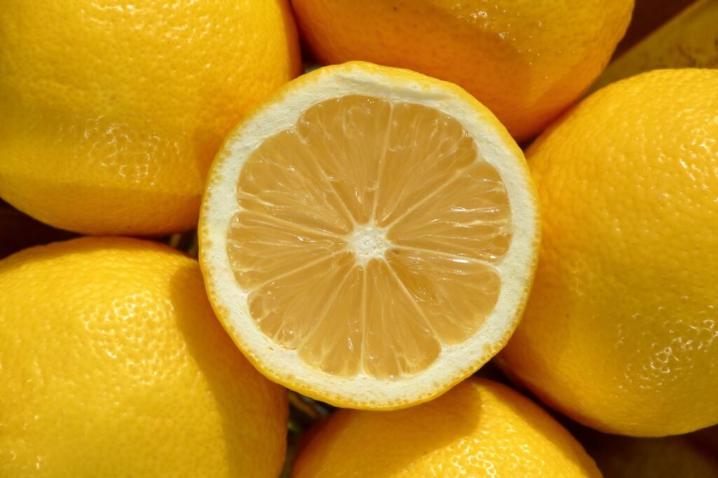 Vibrant close-up of whole and halved lemons showcasing fresh texture and bright color.